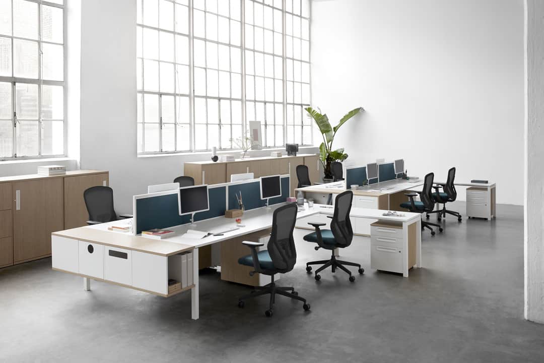 Plain white well lit modern office with desks and chairs